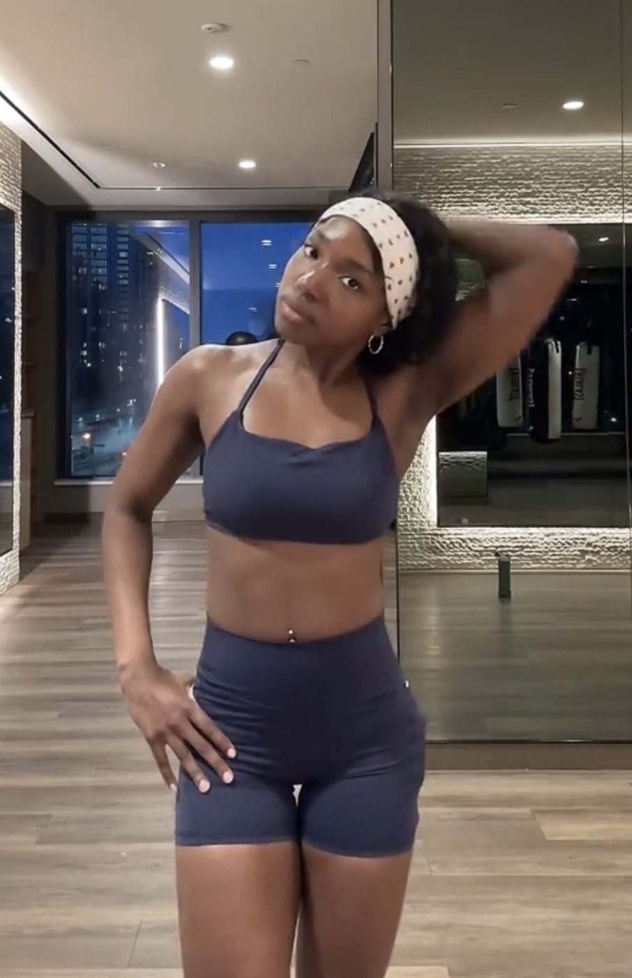 Grace now, in a gym with the city skyline behind her